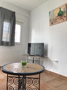 a living room with a table and a tv at Casa Azul in Bolonia