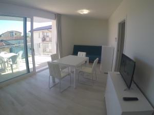 ein Wohnzimmer mit einem weißen Tisch und Stühlen in der Unterkunft Mare Incanto - Agenzia Cocal in Caorle