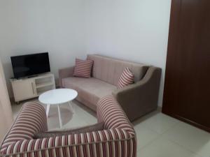 uma sala de estar com um sofá e duas cadeiras e uma mesa em Apartments Alena em Bar