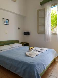 a bedroom with a bed with two towels on it at Amaranto Rooms in Aegiali