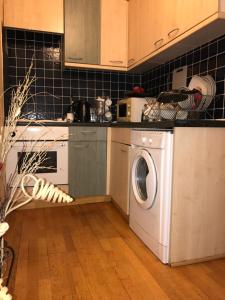 a kitchen with a washing machine in a kitchen at Finchley Road in London
