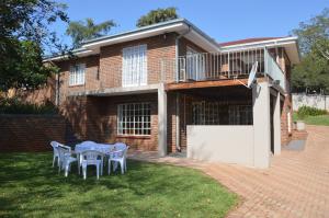 a house with a table and chairs in the yard at Holiday Flat Stormvoel 547 in Hazyview