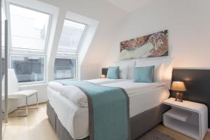 sypialnia z dużym białym łóżkiem i niebieskimi poduszkami w obiekcie Mar Suite Apartments - Center w Wiedniu