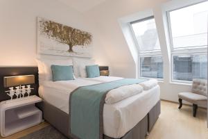 sypialnia z dużym łóżkiem i krzesłem w obiekcie Mar Suite Apartments - Center w Wiedniu