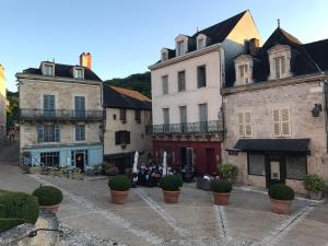a group of buildings in a street with plants at Les Maisons du Périgord in Terrasson-Lavilledieu
