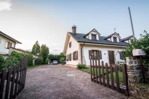 a white house with a fence next to a driveway at casa villa in Gorizia