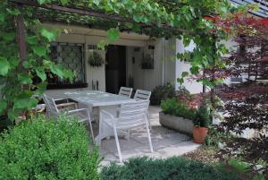 una mesa blanca y sillas en un jardín en Rooms-Apartments Stojanovič, en Bled