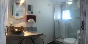 a bathroom with a sink and a toilet and a shower at Lovin Book Guesthouse in Óbidos