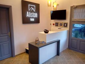 a salon with a reception desk and a tv on the wall at Aliston Hotel Studios, Adults Only in Skala Potamias