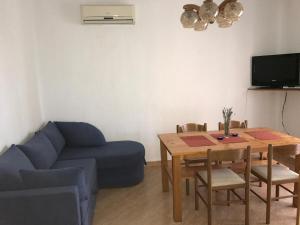 a living room with a blue couch and a table at Apartmani Dora in Vodice