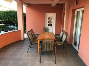 a wooden table and chairs on a patio at Apartmani Dora in Vodice