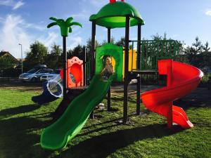 a playground with several different colored slides on the grass at Niebieskie Migdały in Grzybowo