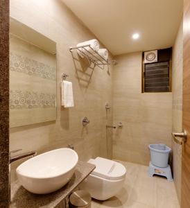 y baño con aseo blanco y lavamanos. en Hotel Shree Sai, en Kolhapur