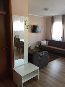 sala de estar con sofá, mesa y espejo en Apartments Petra, en Slunj