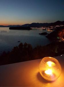 a candle sitting on a table with a view of a lake at Villa Crawford in San Nicola Arcella