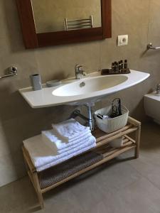 a bathroom with a sink with towels and a mirror at Villa Crawford in San Nicola Arcella