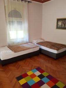 2 Betten in einem Zimmer mit farbenfrohem Teppich in der Unterkunft Rooms Portorose Center in Portorož