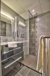 a bathroom with a shower and a sink at Logis Hôtel Restaurant Le Chalet du Mont Roland in Dole