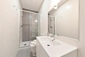 a white bathroom with a sink and a toilet at Sleep in Centre in Porto