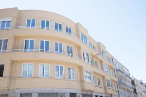 a yellow building with blue windows on it at Sleep in Centre in Porto