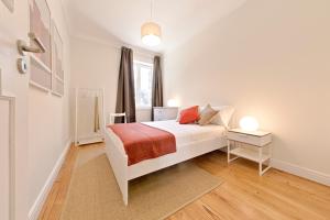 a white bedroom with a bed and a window at Sleep in Centre in Porto