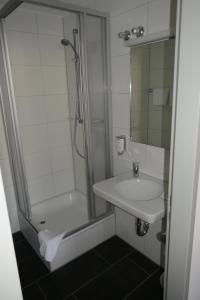uma casa de banho com um chuveiro e um lavatório. em Bayerischer Hof em Burghausen