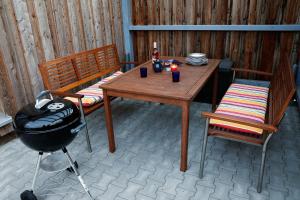 een patio met een tafel, 2 stoelen en een grill bij Gästehaus Plath in Wettringen
