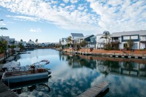 a boat is docked in a river with houses at 3 Spinnaker The Quays in Knysna