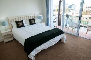 a bedroom with a large bed and a balcony at 3 Spinnaker The Quays in Knysna