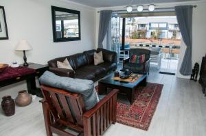 a living room with a leather couch and a table at 3 Spinnaker The Quays in Knysna