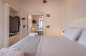 a white bedroom with a large white bed in it at Plaka Suites in Plaka Milou