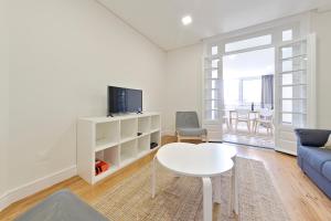 a living room with a couch and a table and a tv at Sleep in Centre Downtown in Porto