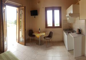 a small kitchen with a table and chairs in a room at Epi Apartments in Lourdata