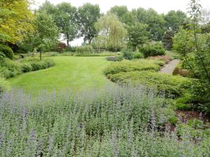 a garden with purple flowers in the middle at B&B 't Hekkert in Gorssel