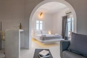 a white room with a bed and a couch at Plaka Suites in Plaka Milou