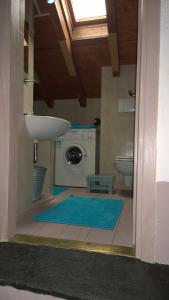 a bathroom with a sink and a washing machine at B&B "A Casa di Camilla" in Carate Urio