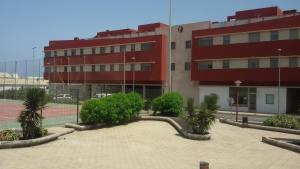 a large red building with trees in front of it at Apartamento fuerte 1 in Puerto del Rosario