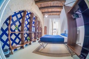 um quarto com uma cama azul num quarto em Per Amor Duomo em Nápoles