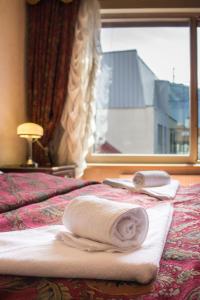pokój hotelowy z ręcznikami na łóżku z oknem w obiekcie Old Riga terrace apartment w Rydze