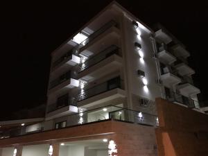 een hoog gebouw met 's nachts verlichting bij Guesthouse Montex in Sutomore