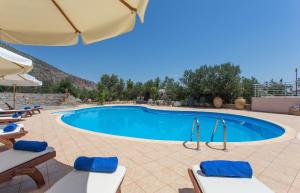 - une piscine dans un complexe avec des chaises et un parasol dans l'établissement Monemvasia Village (ex Topalti), à Monemvasia