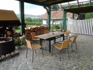 einen Holztisch und Stühle auf einer Terrasse in der Unterkunft Kozí Dvor Rohozná in Brezno