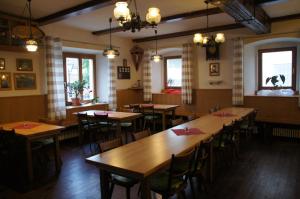 a restaurant with wooden tables and chairs and windows at Gaststätte Liebl in Wiesent