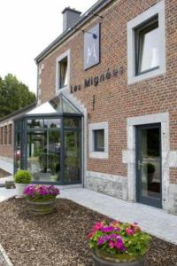 a brick building with two pots of flowers in front of it at Hotel Les Mignees in Barvaux