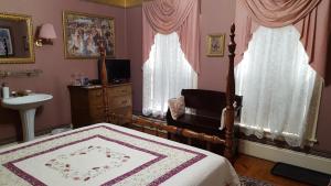 a bedroom with a canopy bed and a sink and a sink at Holidae House Bed & Breakfast in Bethel