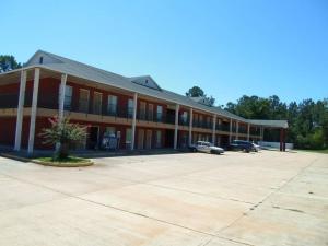 een groot gebouw met auto's geparkeerd op een parkeerplaats bij Homegate Inn in Louisville