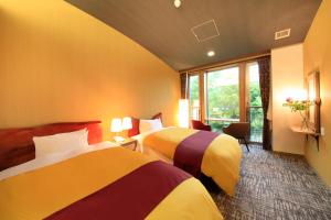 a hotel room with two beds and a window at Hakone Fuga (Adult Only) in Hakone