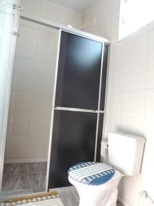 a bathroom with a toilet with a glass shower door at Pousada Centaurus in Alto Paraíso de Goiás