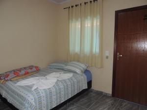 a bedroom with a bed with towels on it at Pousada Centaurus in Alto Paraíso de Goiás