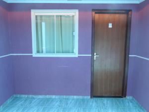 a door in a room with purple walls and a window at Pousada Centaurus in Alto Paraíso de Goiás